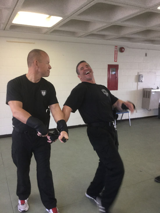 Men in black t-shirts practicing OPN restraint techniques.